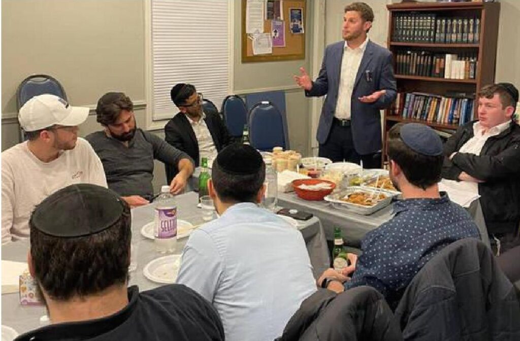Ben Rand addressing a group of Baalei Tshuva (newly religious) men who join PTI’s Young Professionals program every Thursday at 8pm.. Image Credit - YNB-PTI